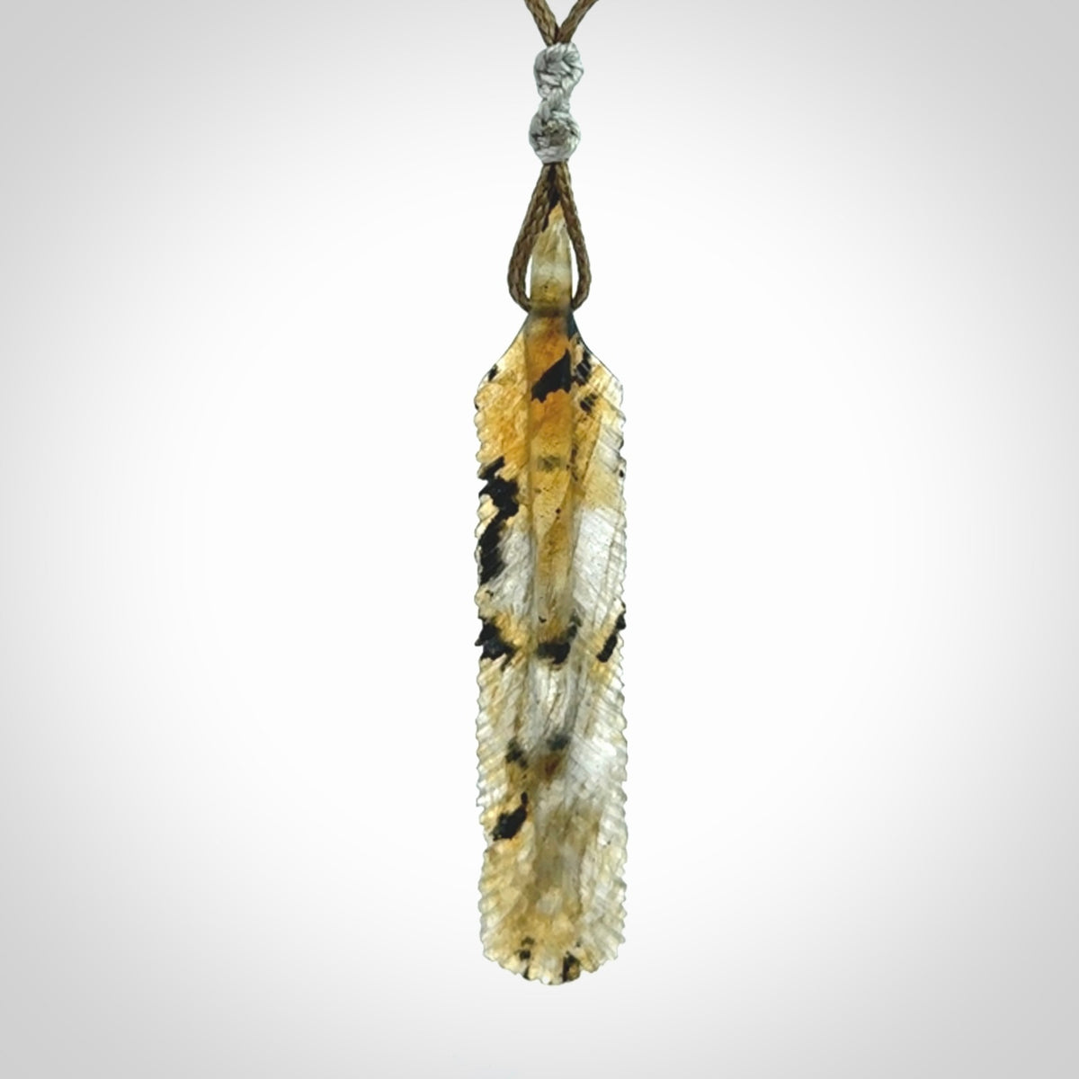 This is a hand carved feather pendant made from Labradorite stone.