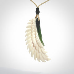 This photo shows a beautiful bone and jade wing pendant.