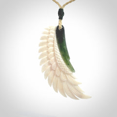 This photo shows a beautiful bone and jade wing pendant.