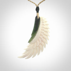 This photo shows a beautiful bone and jade wing pendant.
