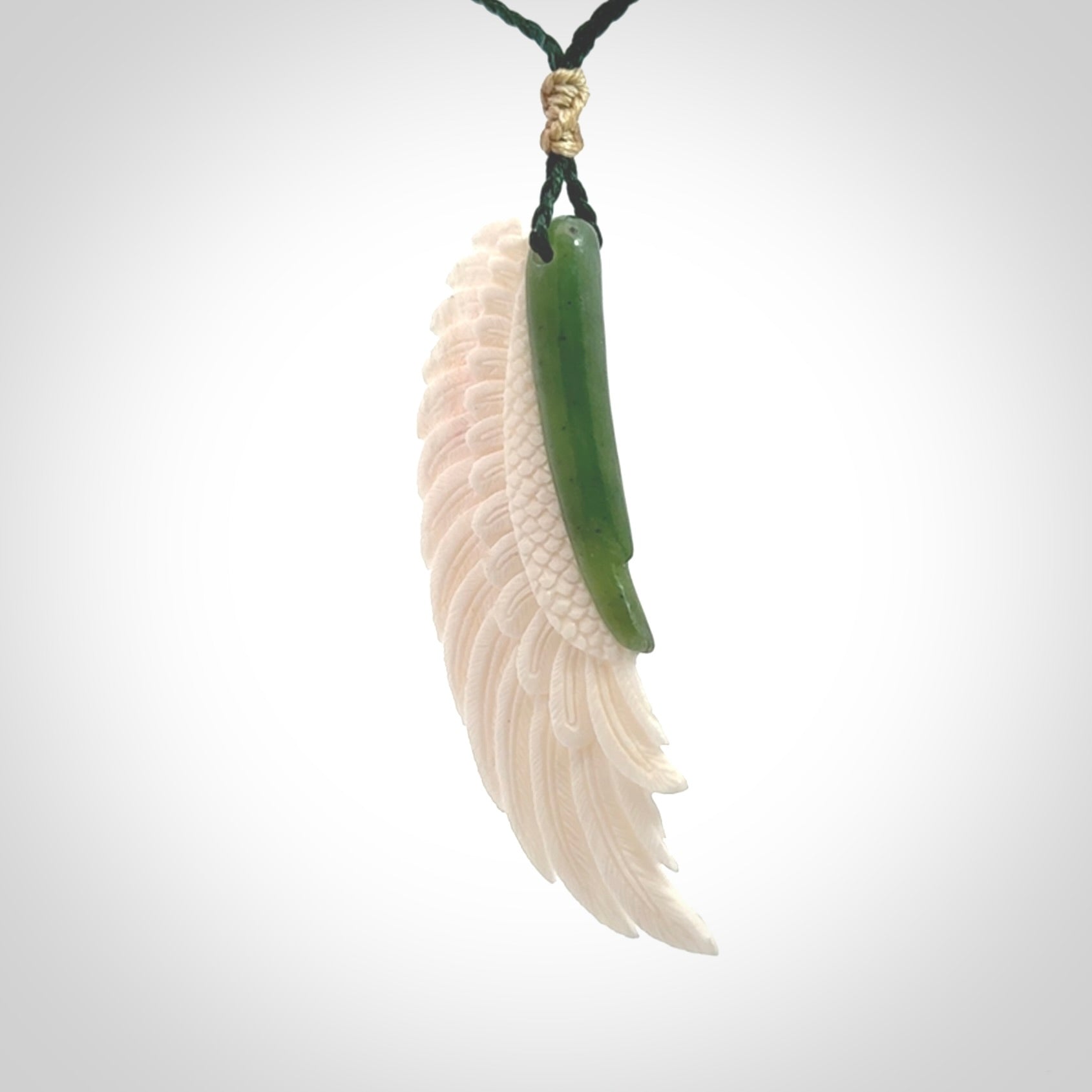This photo shows a beautiful bone and jade wing pendant.
