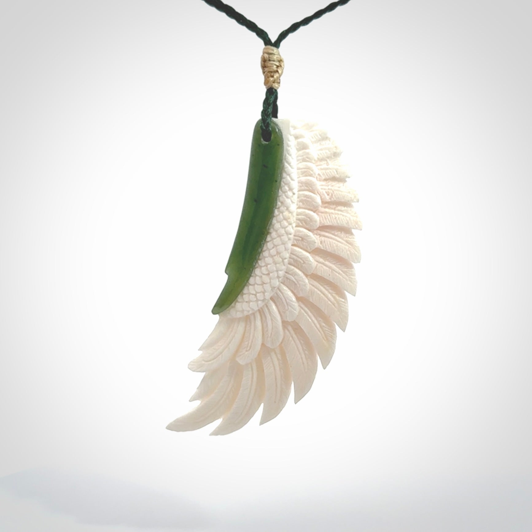 This photo shows a beautiful bone and jade wing pendant.