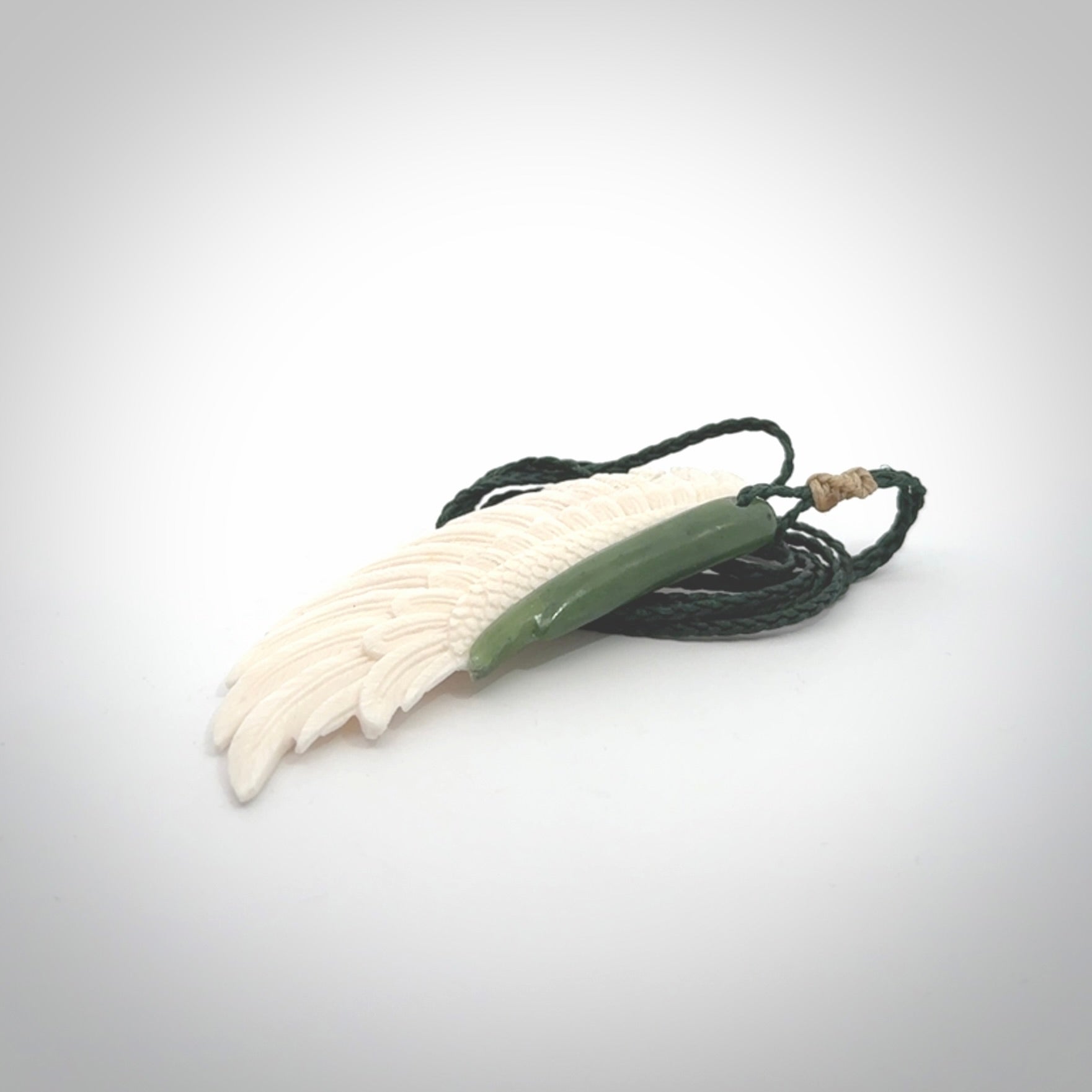 This photo shows a beautiful bone and jade wing pendant.