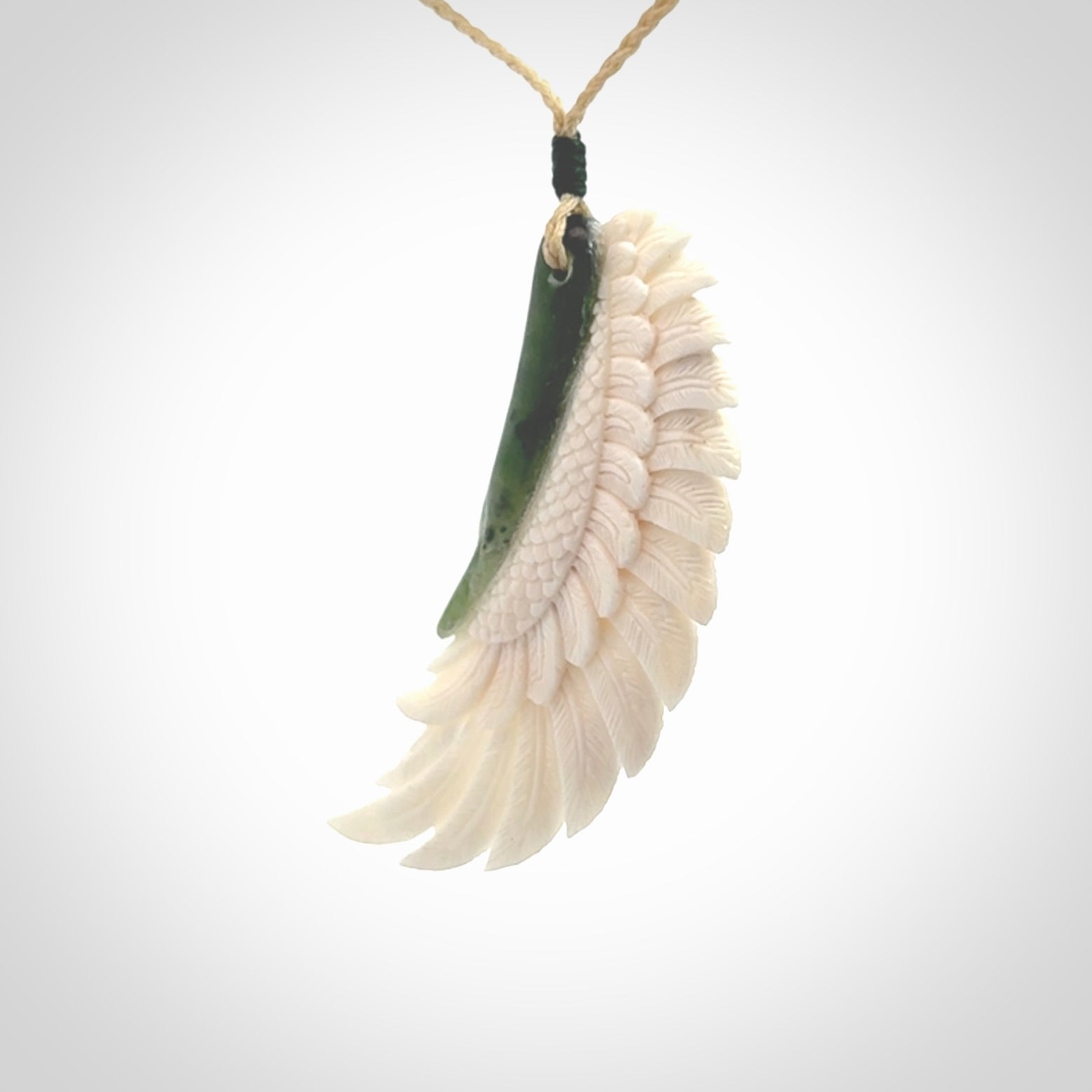 This photo shows a beautiful bone and jade wing pendant.