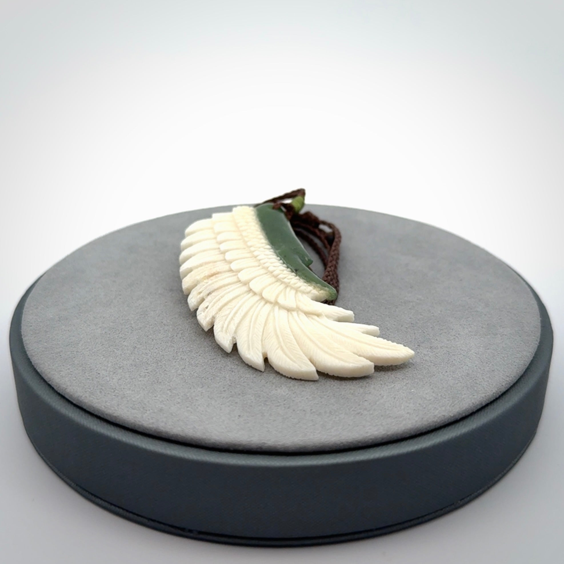 This photo shows a beautiful bone and jade wing pendant.
