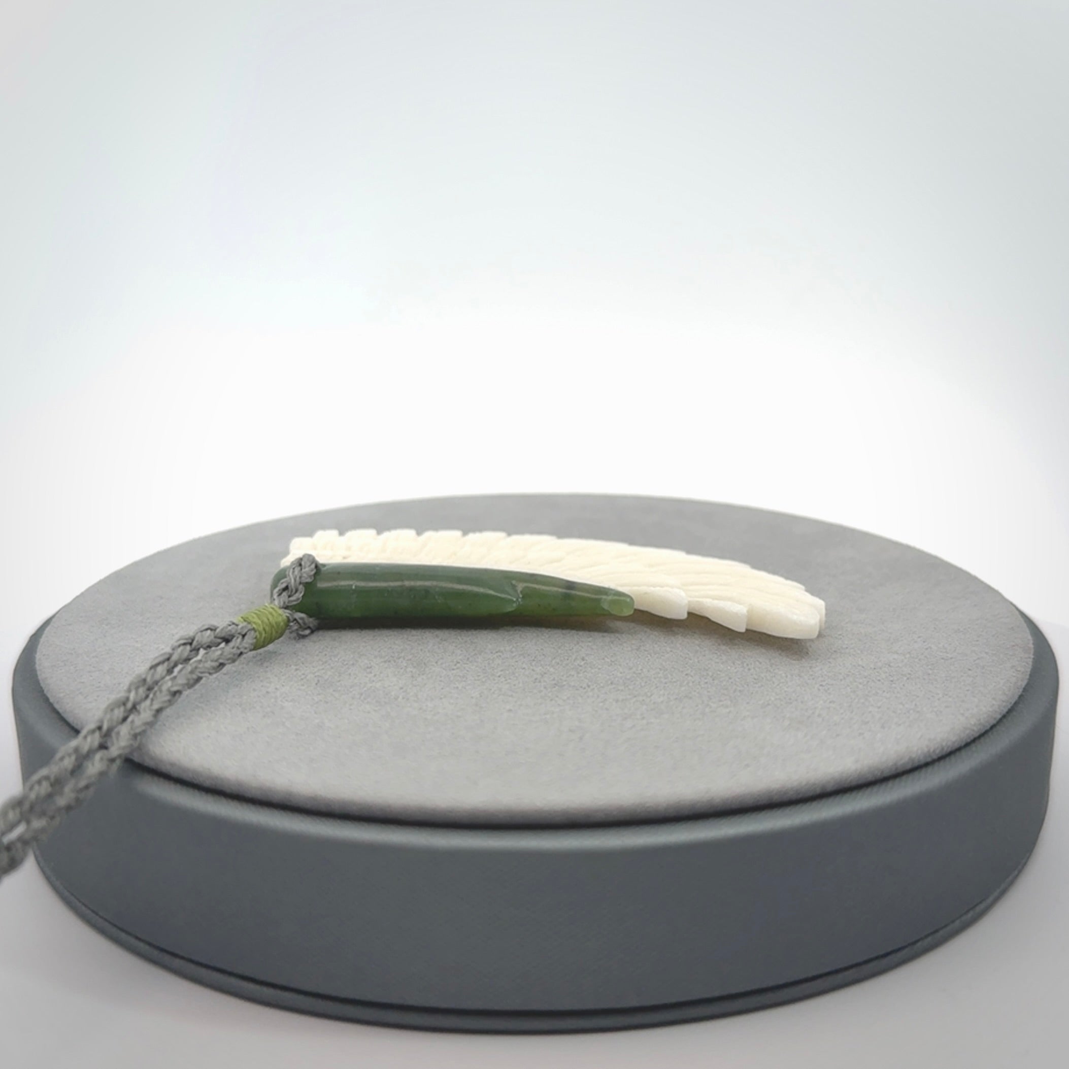This photo shows a beautiful bone and jade wing pendant.