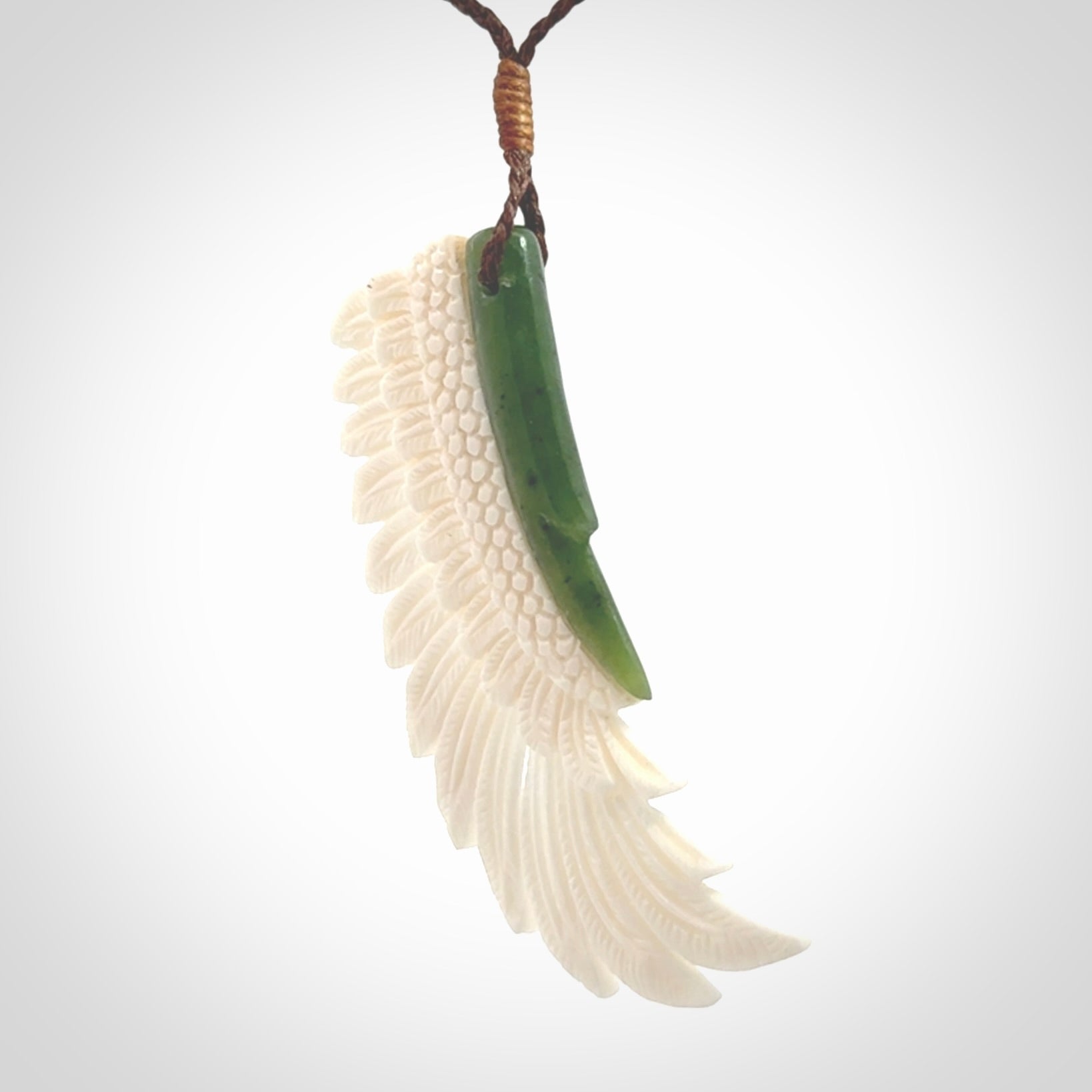 This photo shows a beautiful bone and jade wing pendant.