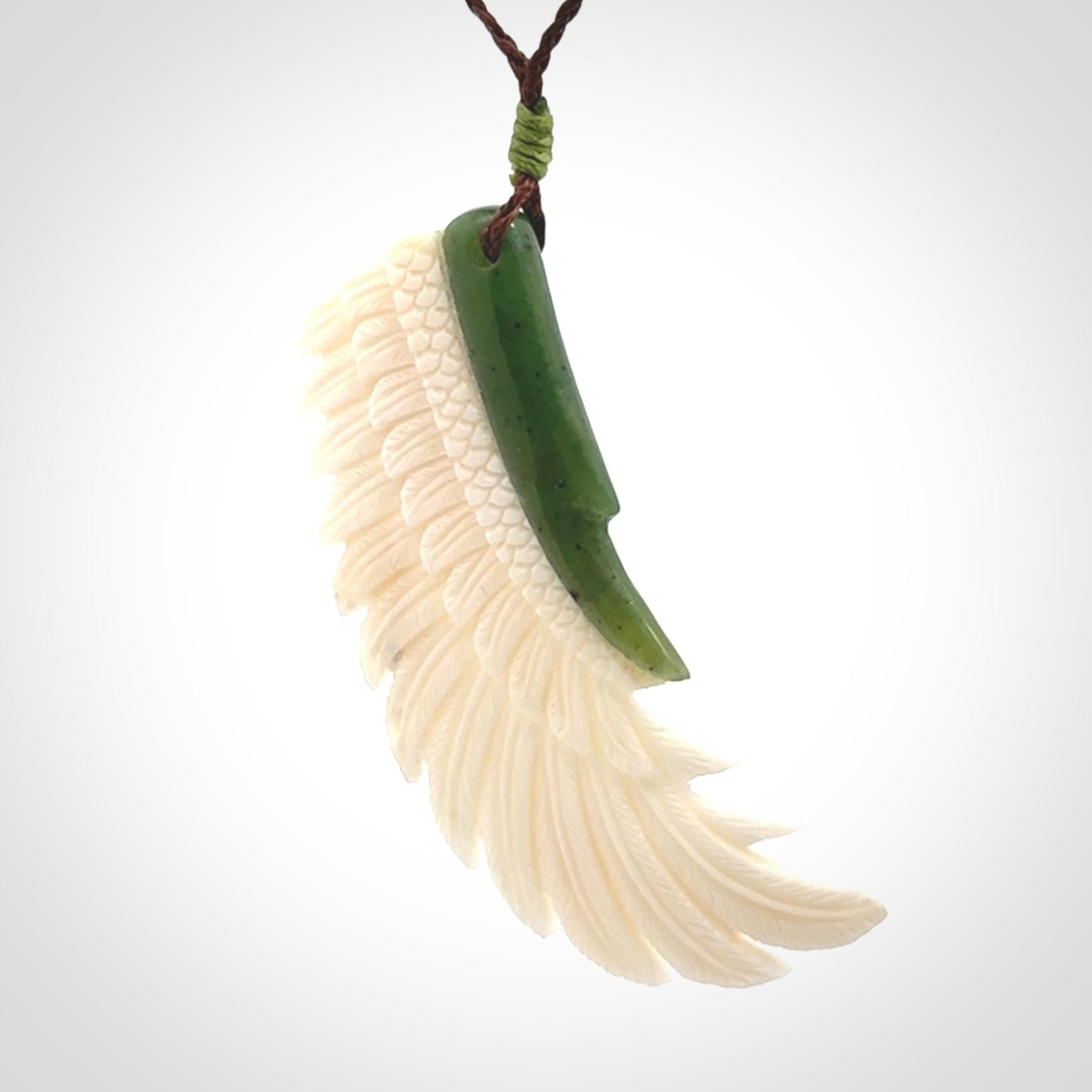 This photo shows a beautiful bone and jade wing pendant.