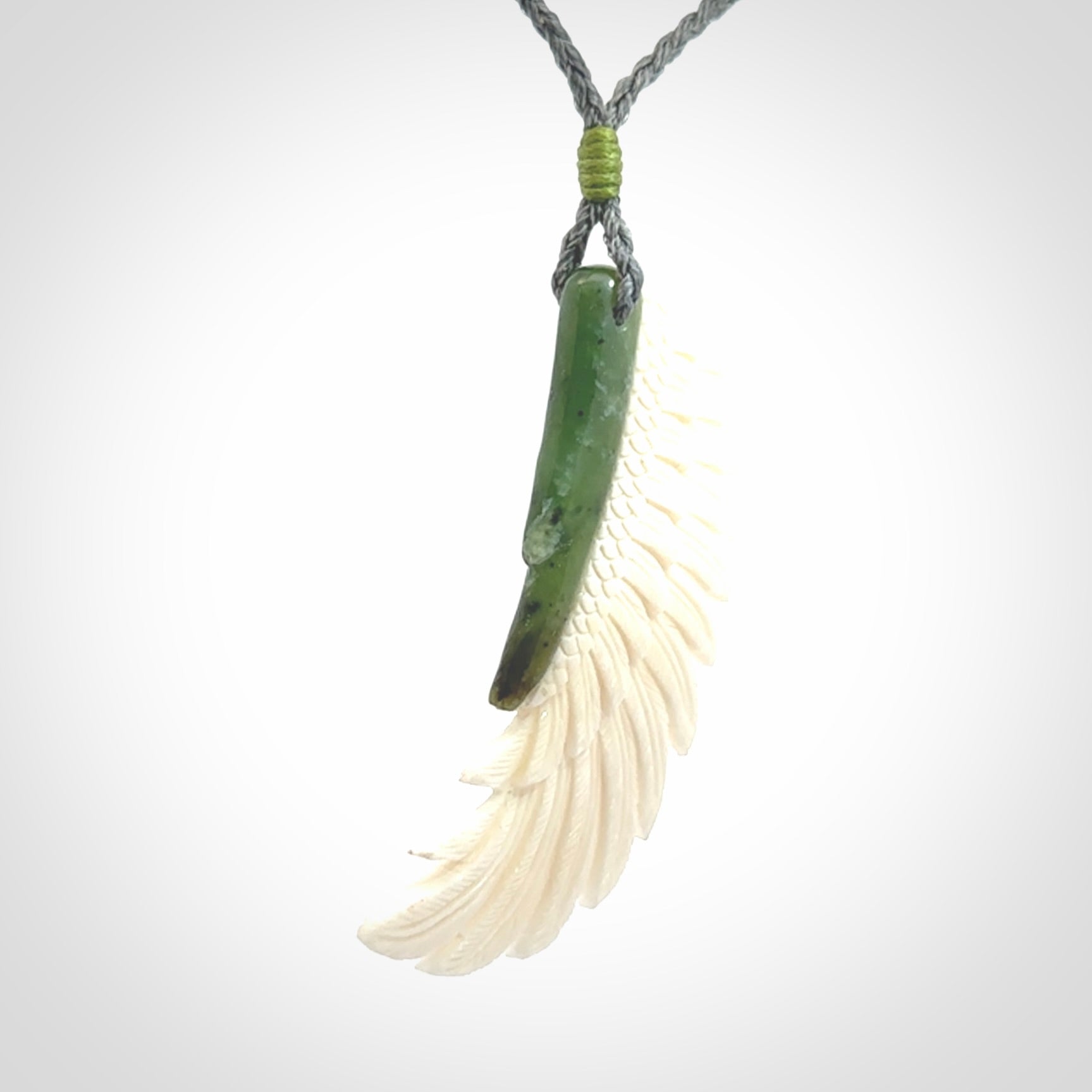 This photo shows a beautiful bone and jade wing pendant.