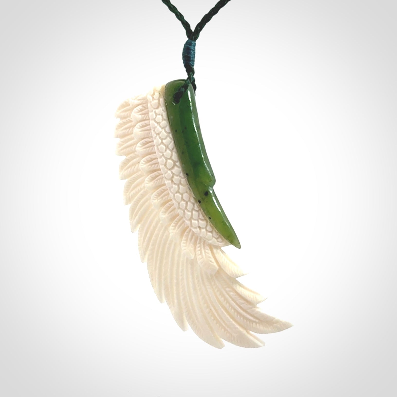 This photo shows a beautiful bone and jade wing pendant.