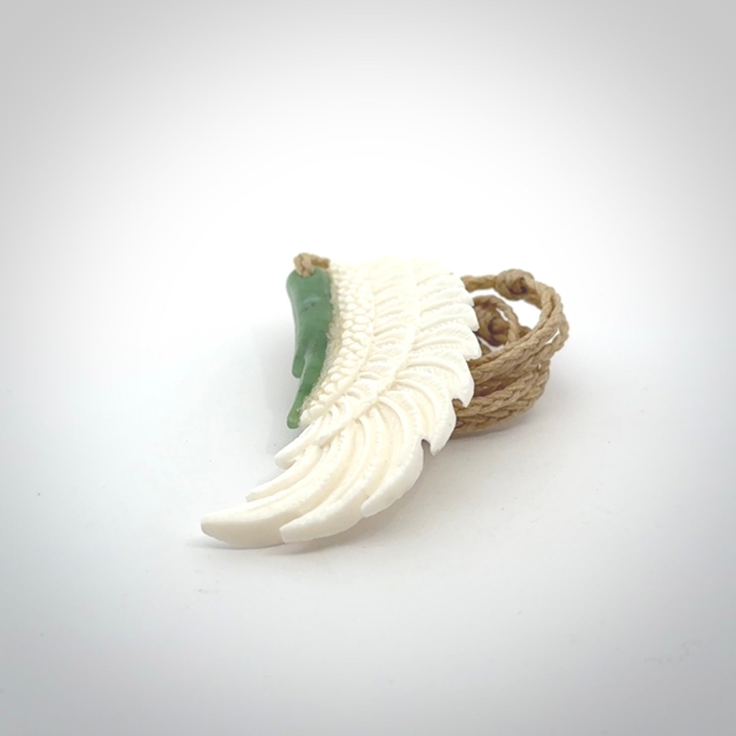 This photo shows a beautiful bone and jade wing pendant.