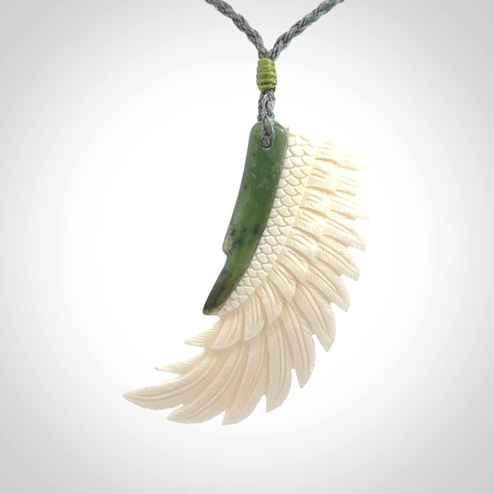 This photo shows a beautiful bone and jade wing pendant.