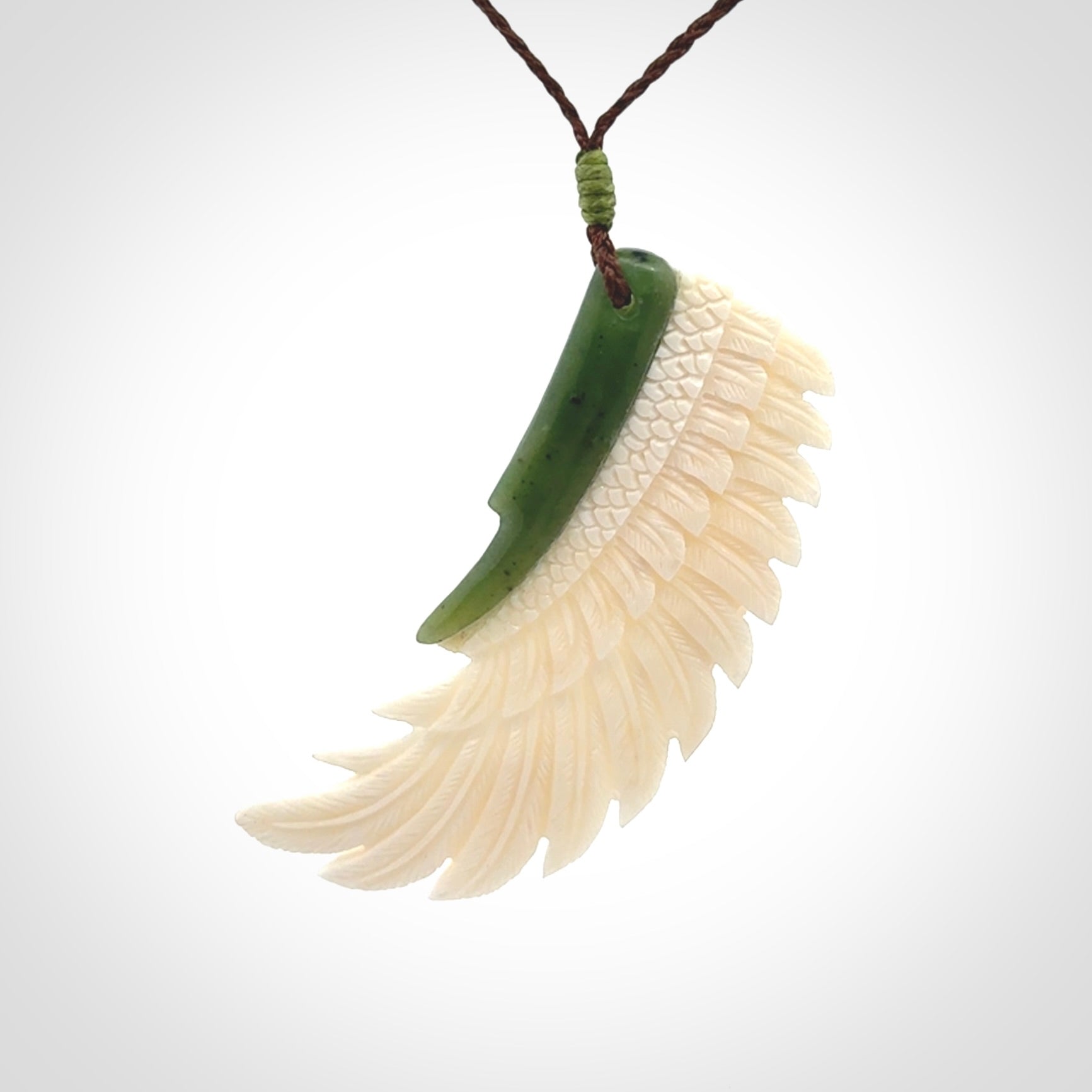 This photo shows a beautiful bone and jade wing pendant.