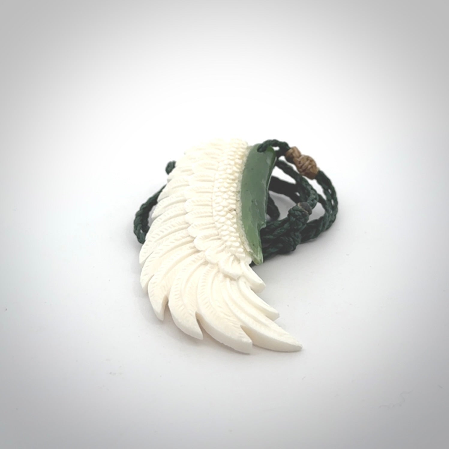 This photo shows a beautiful bone and jade wing pendant.