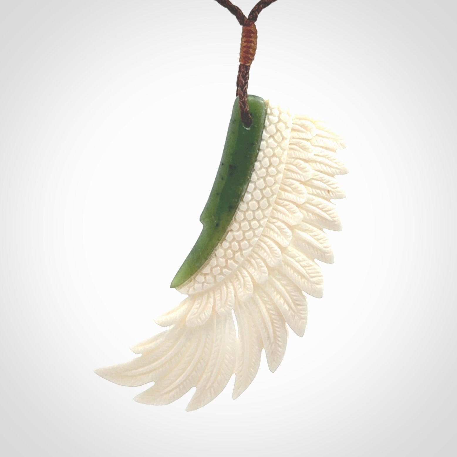 This photo shows a beautiful bone and jade wing pendant.