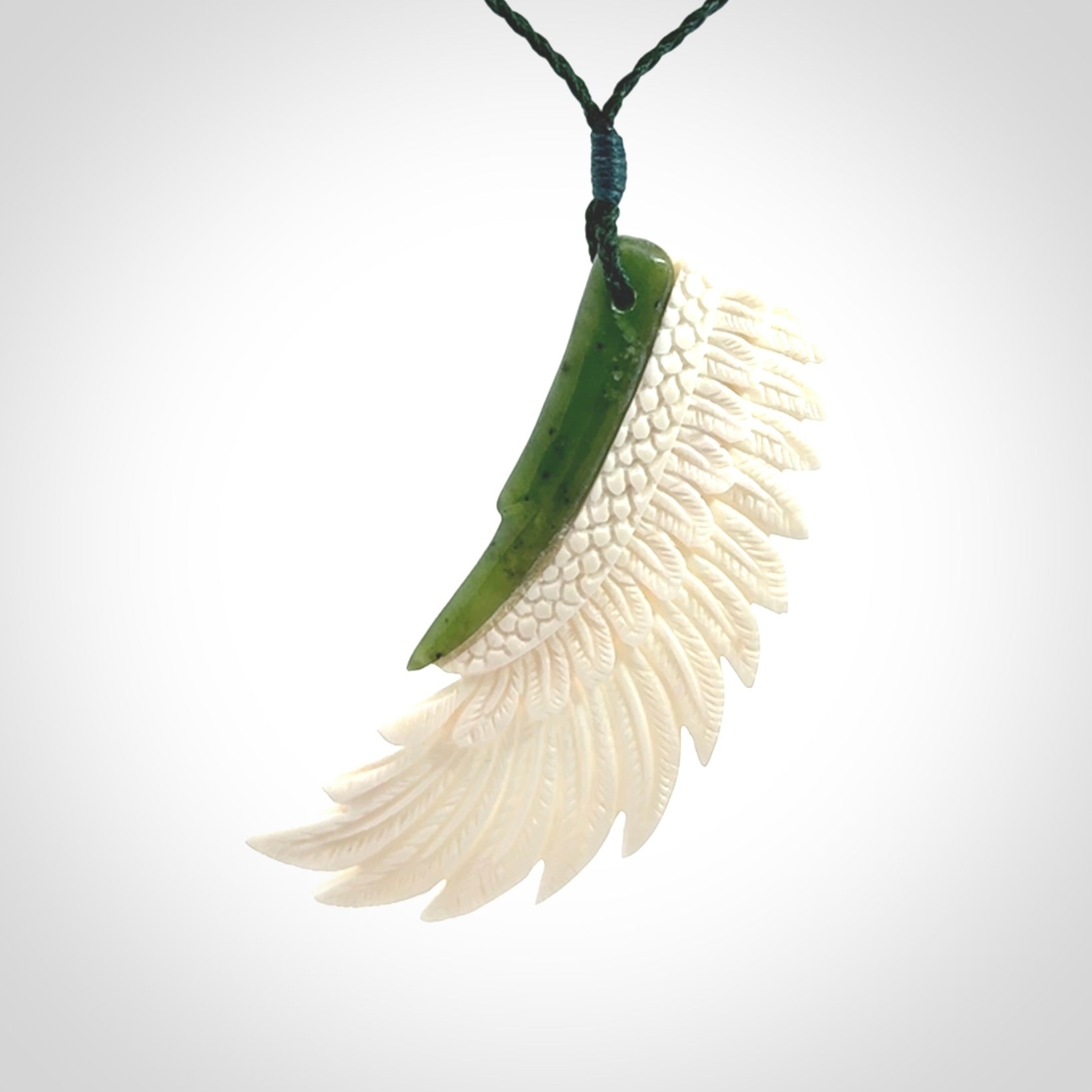 This photo shows a beautiful bone and jade wing pendant.