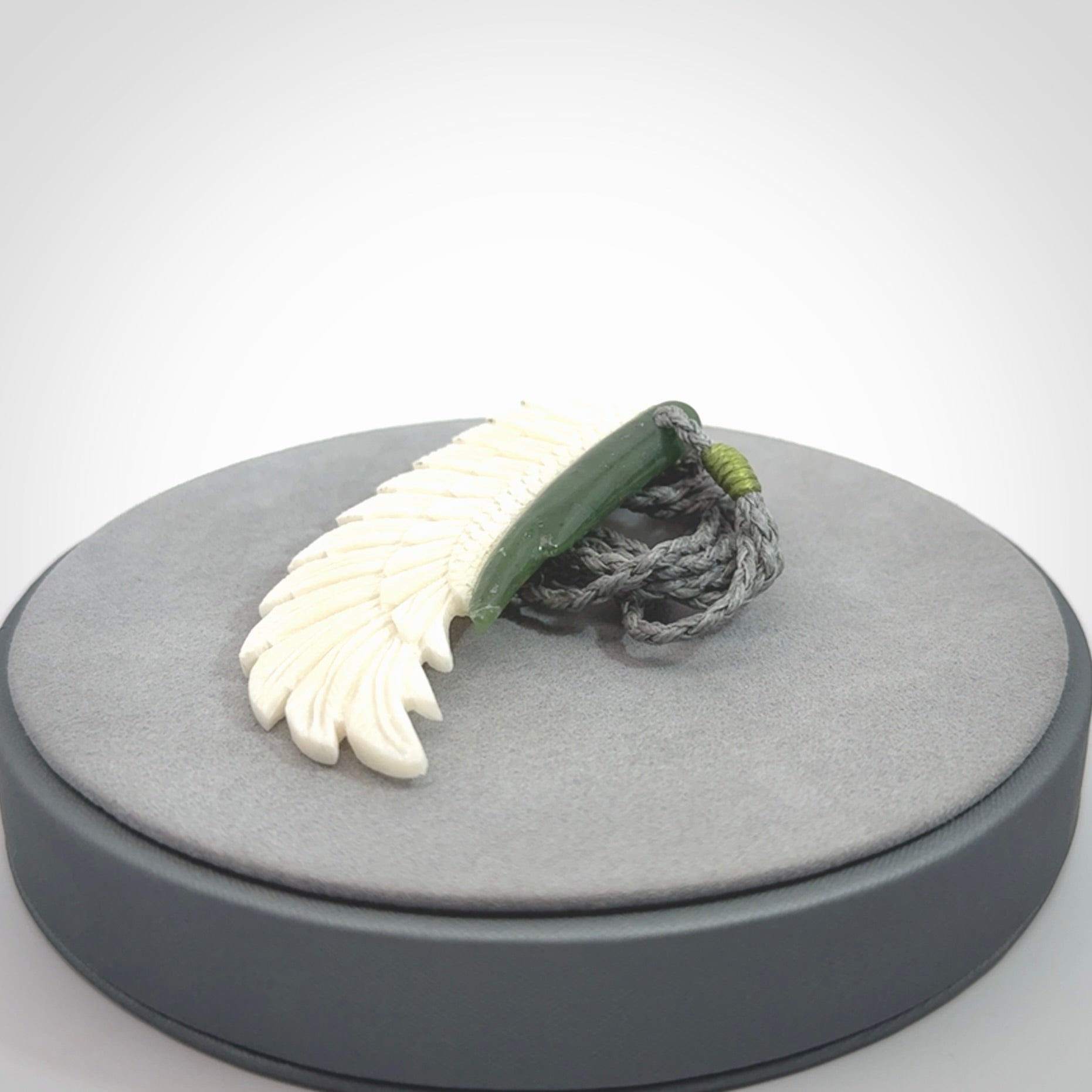 This photo shows a beautiful bone and jade wing pendant.