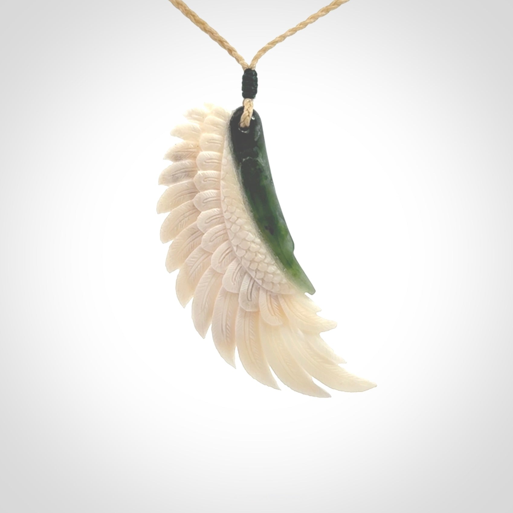 This photo shows a beautiful bone and jade wing pendant.