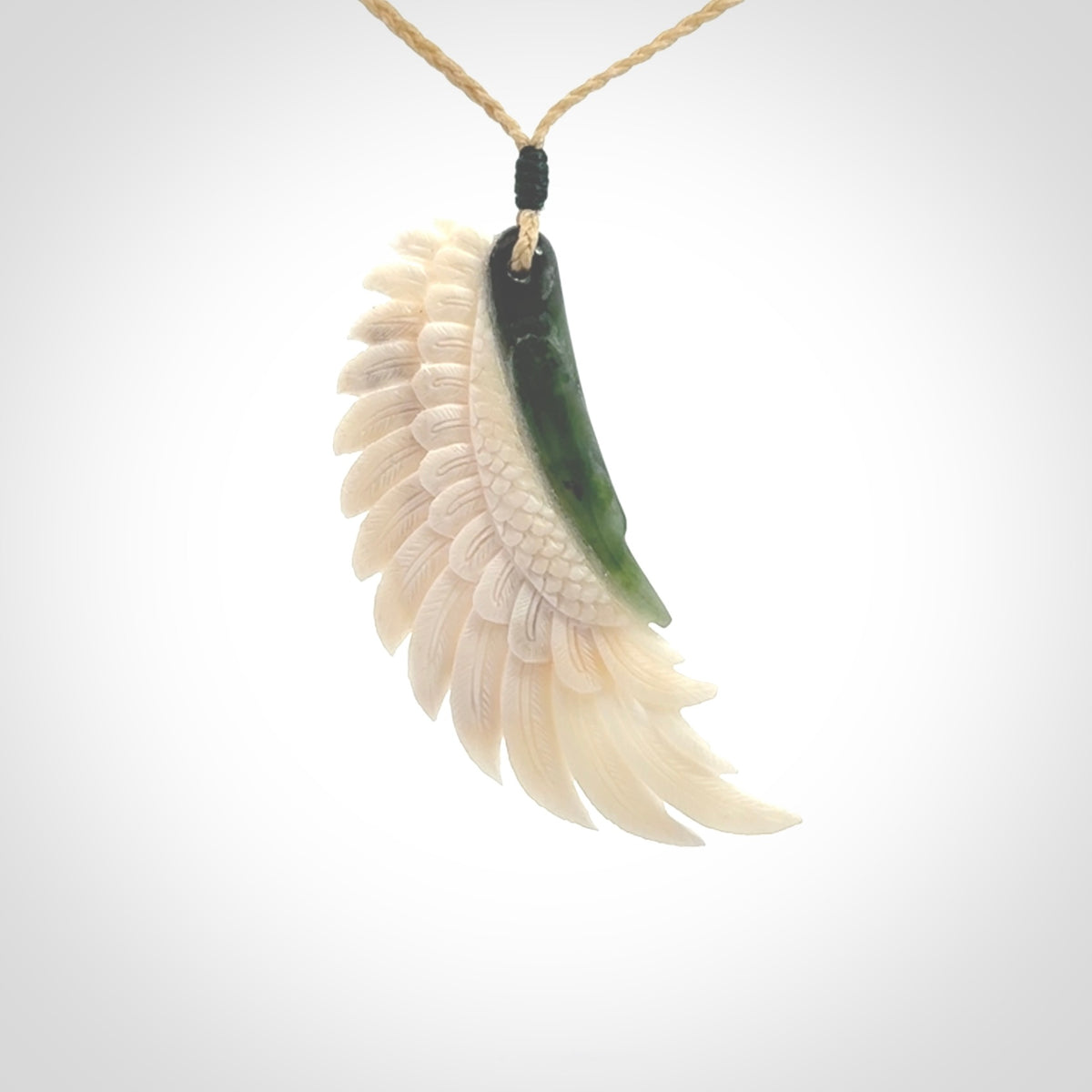 This photo shows a beautiful bone and jade wing pendant.