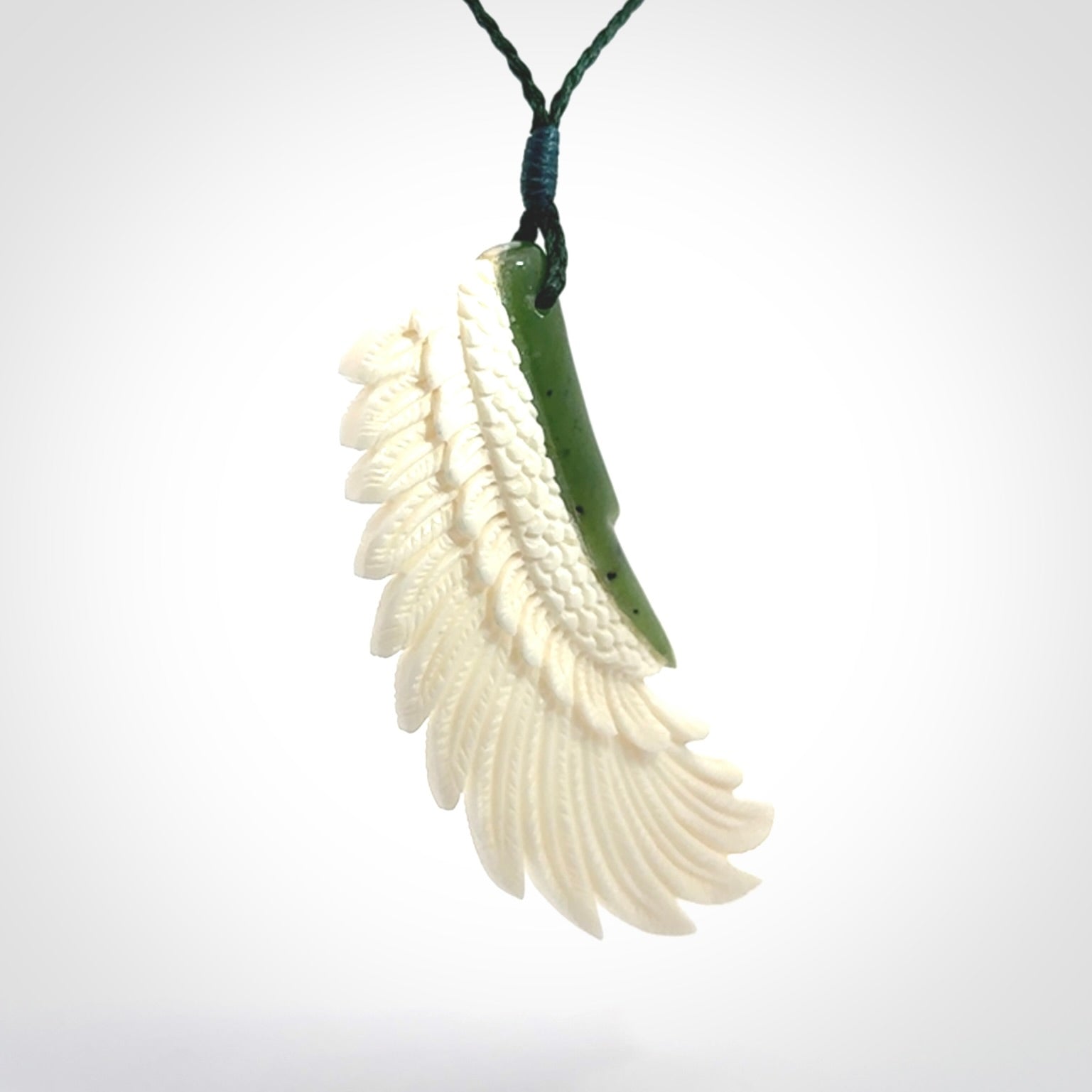 This photo shows a beautiful bone and jade wing pendant.