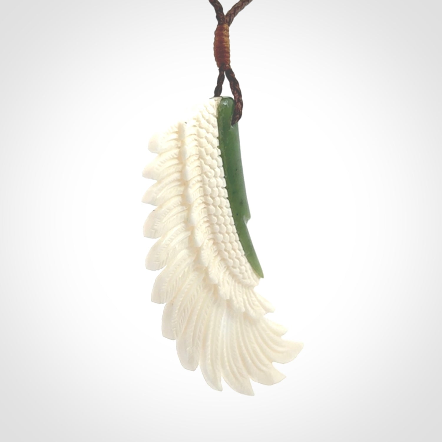 This photo shows a beautiful bone and jade wing pendant.