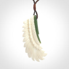 This photo shows a beautiful bone and jade wing pendant.