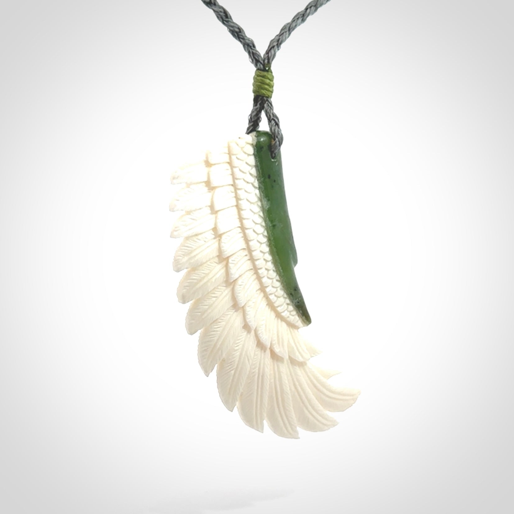 This photo shows a beautiful bone and jade wing pendant.
