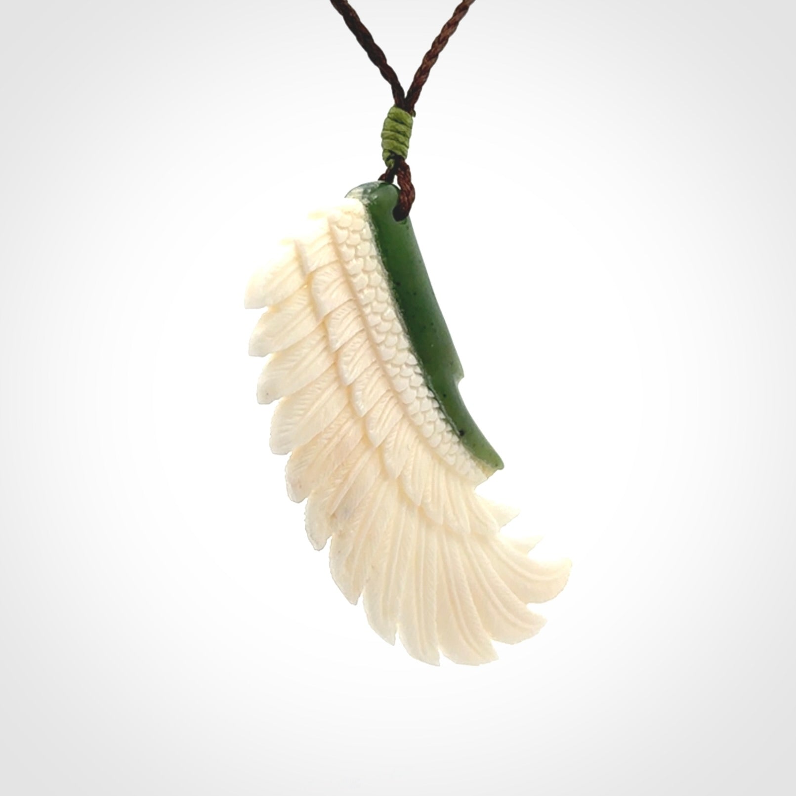 This photo shows a beautiful bone and jade wing pendant.