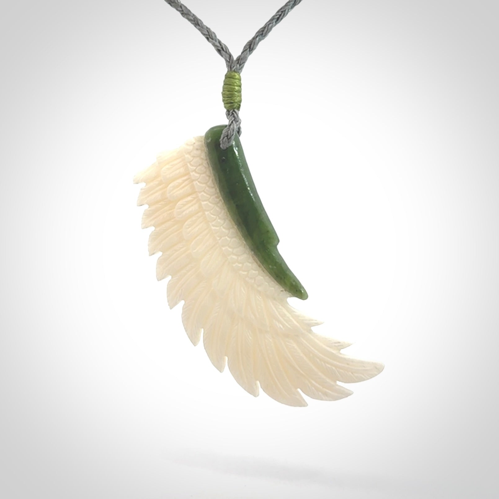 This photo shows a beautiful bone and jade wing pendant.