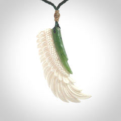 This photo shows a beautiful bone and jade wing pendant.