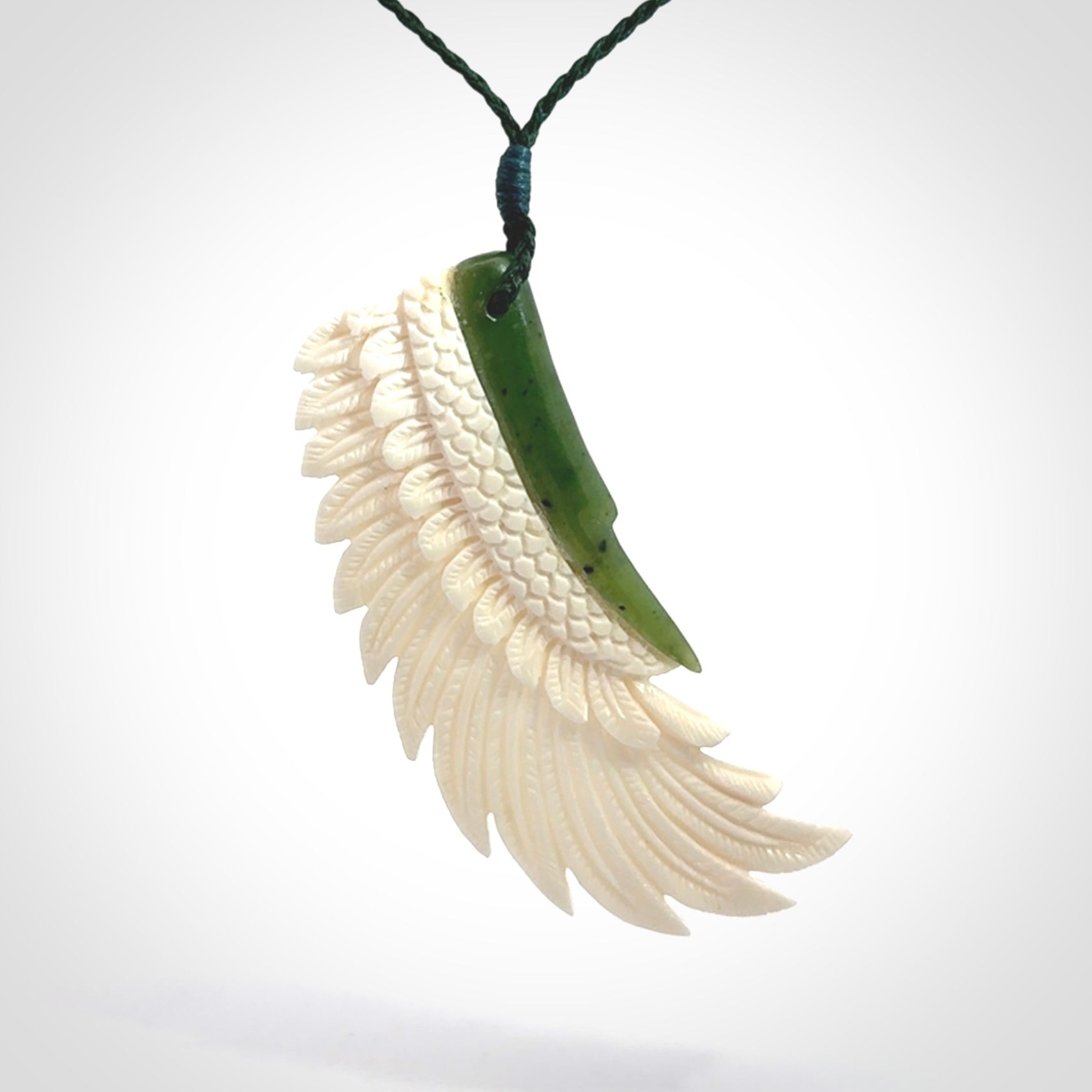 This photo shows a beautiful bone and jade wing pendant.