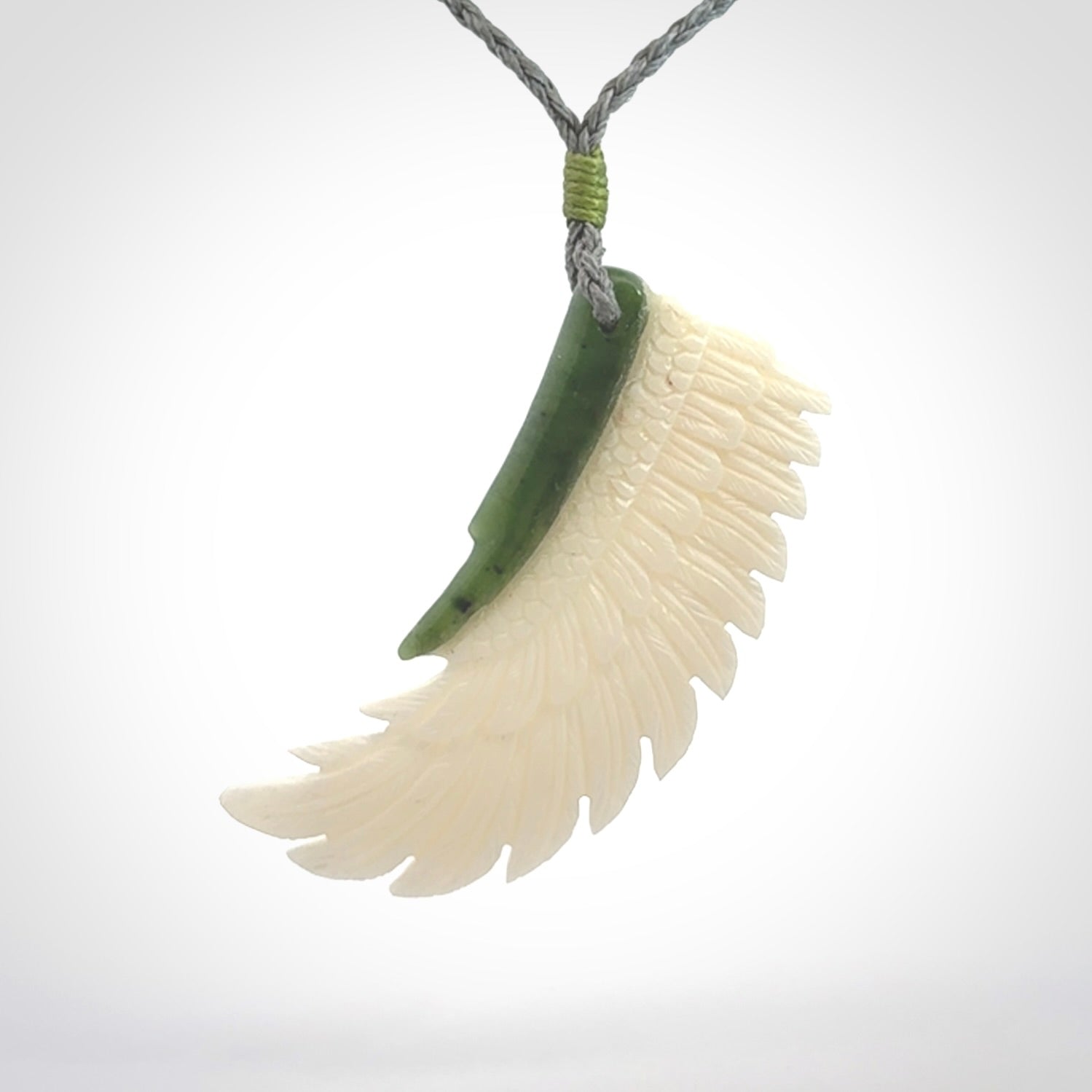 This photo shows a beautiful bone and jade wing pendant.