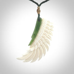 This photo shows a beautiful bone and jade wing pendant.