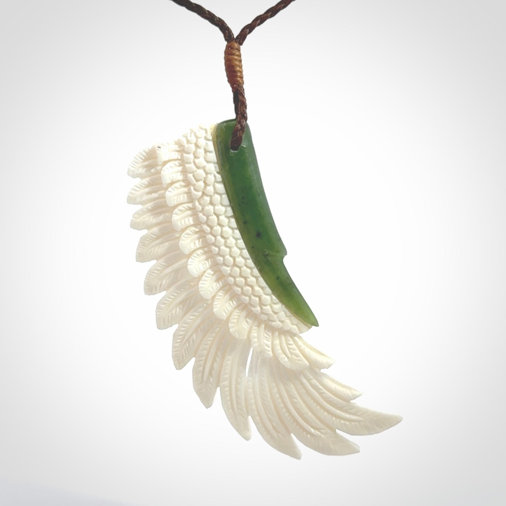 This photo shows a beautiful bone and jade wing pendant.