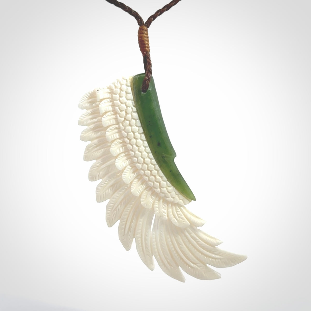 This photo shows a beautiful bone and jade wing pendant.