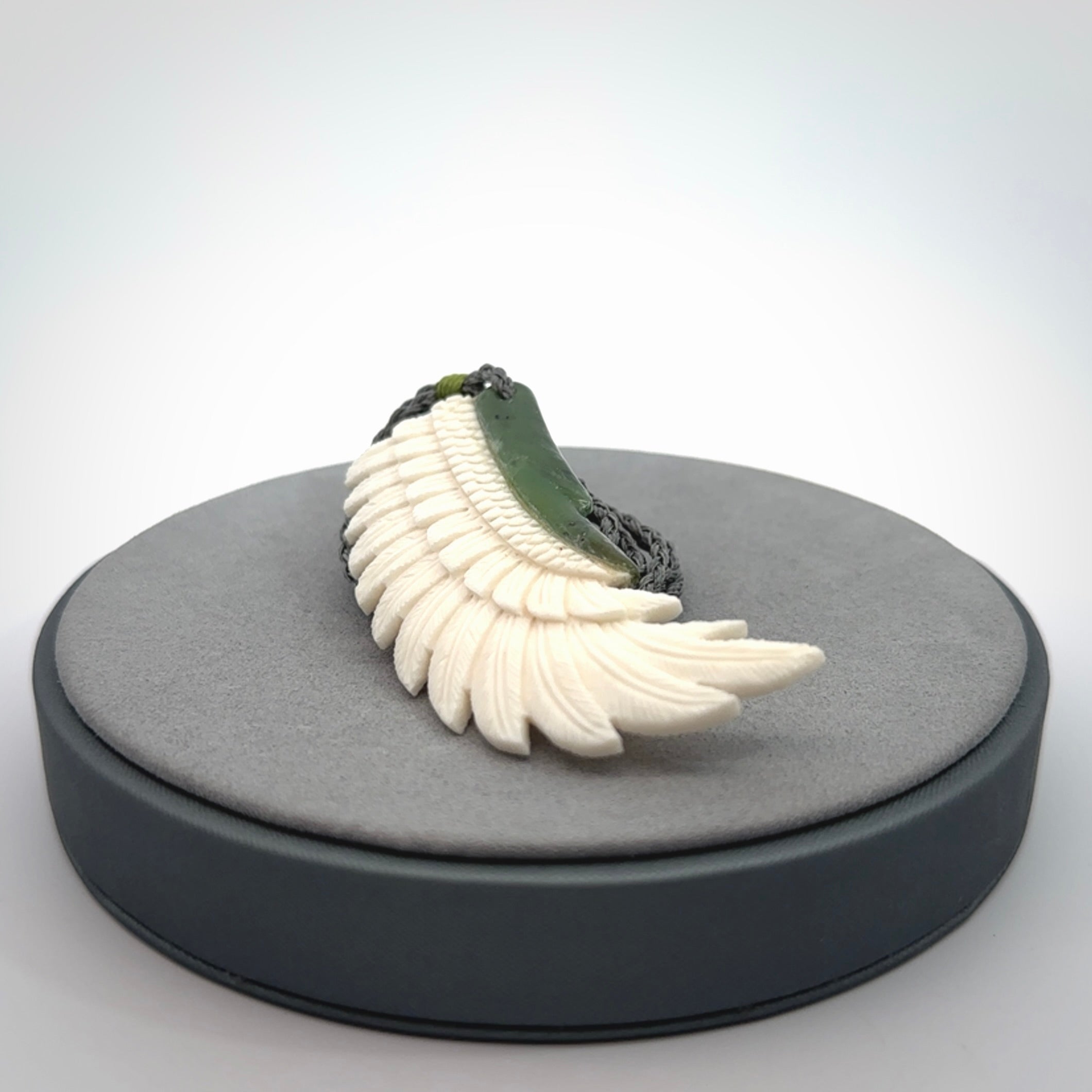 This photo shows a beautiful bone and jade wing pendant.