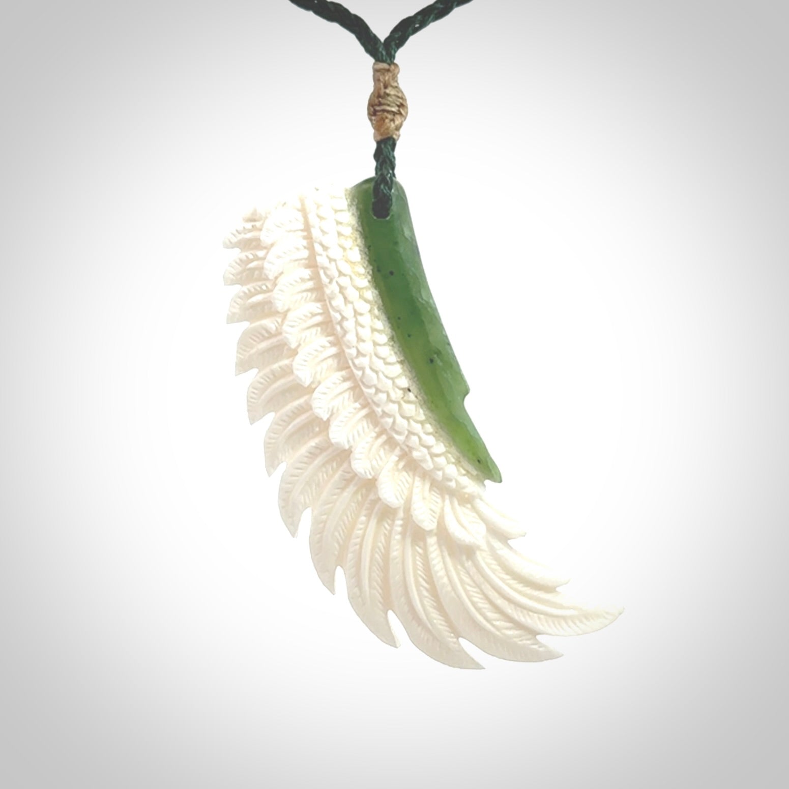This photo shows a beautiful bone and jade wing pendant.