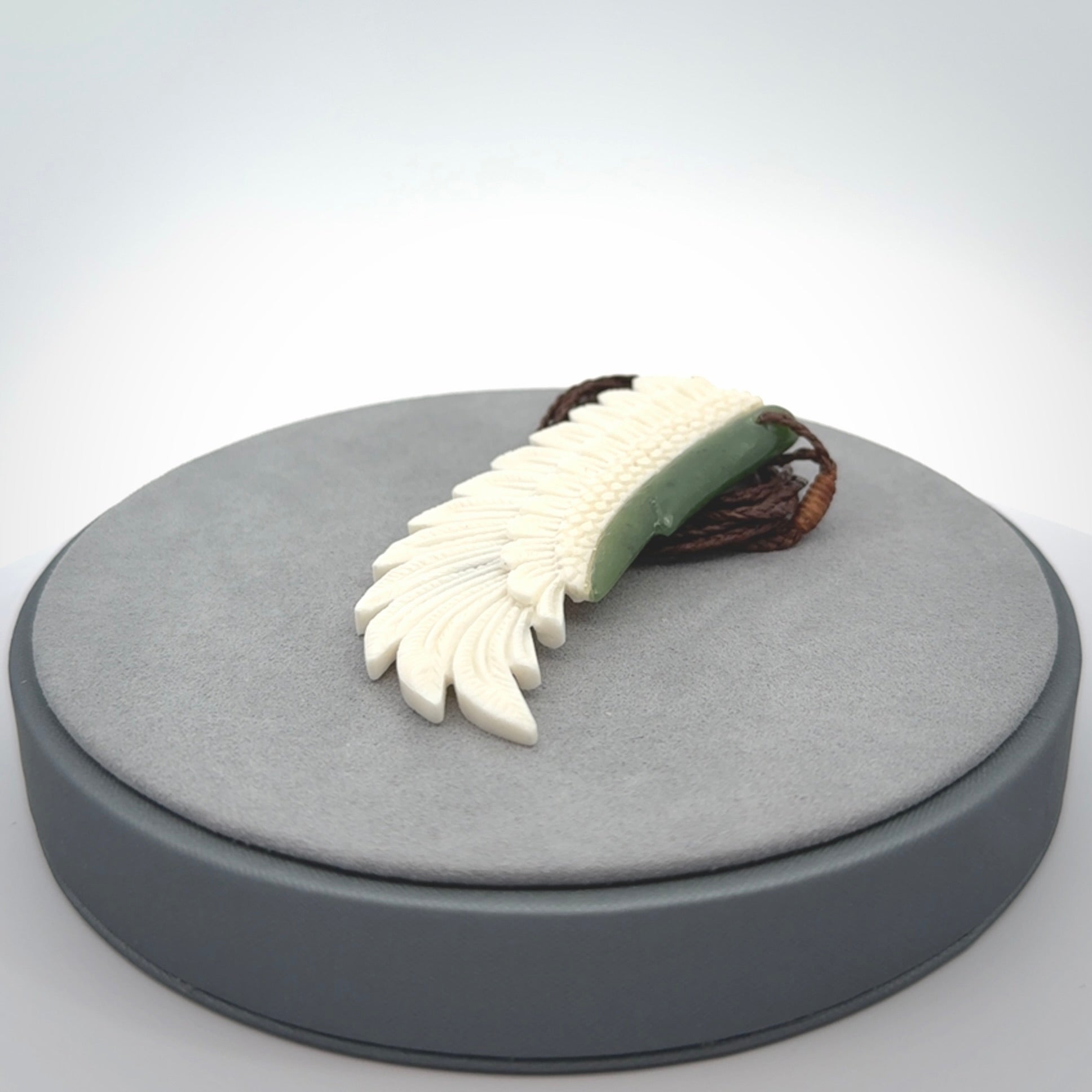 This photo shows a beautiful bone and jade wing pendant.