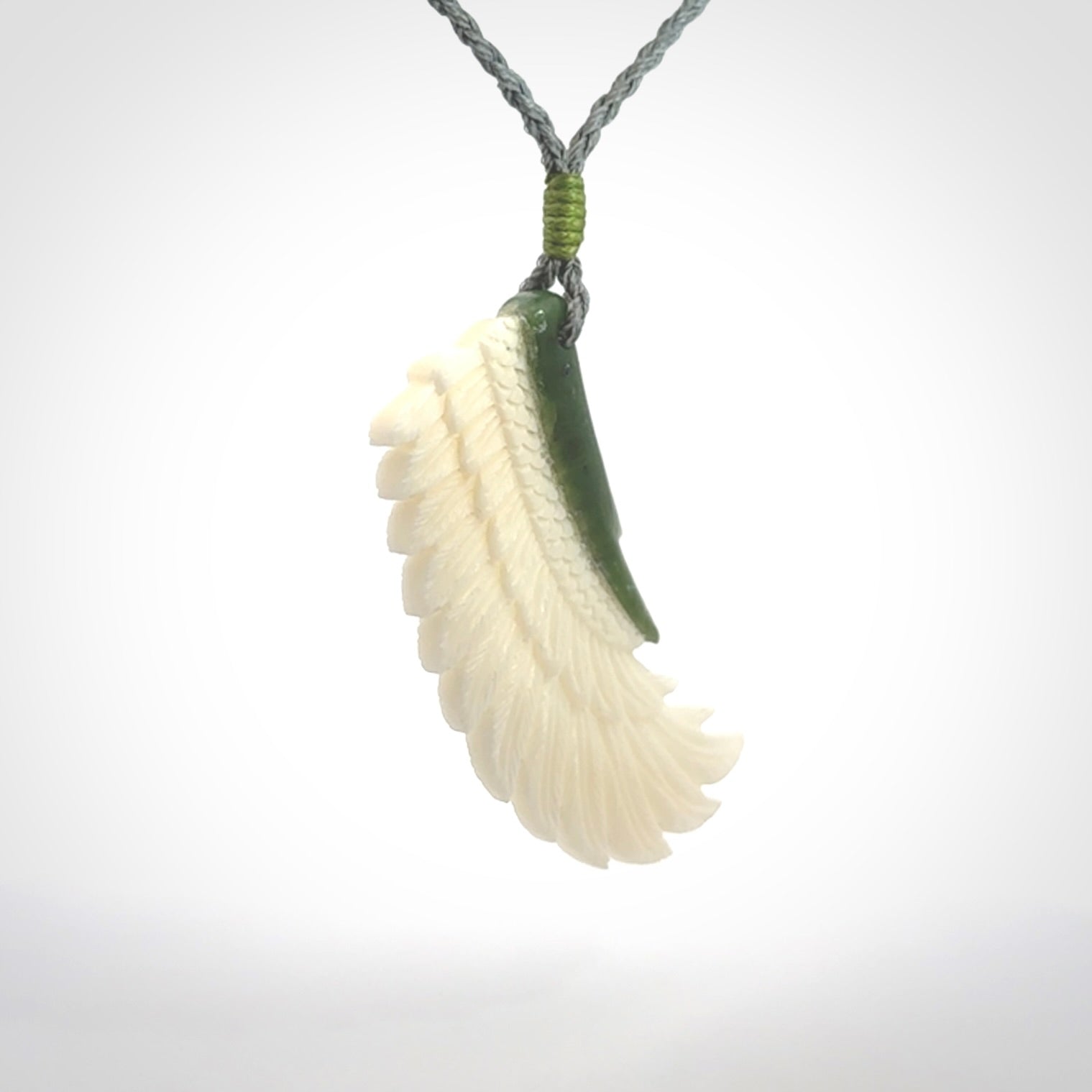 This photo shows a beautiful bone and jade wing pendant.