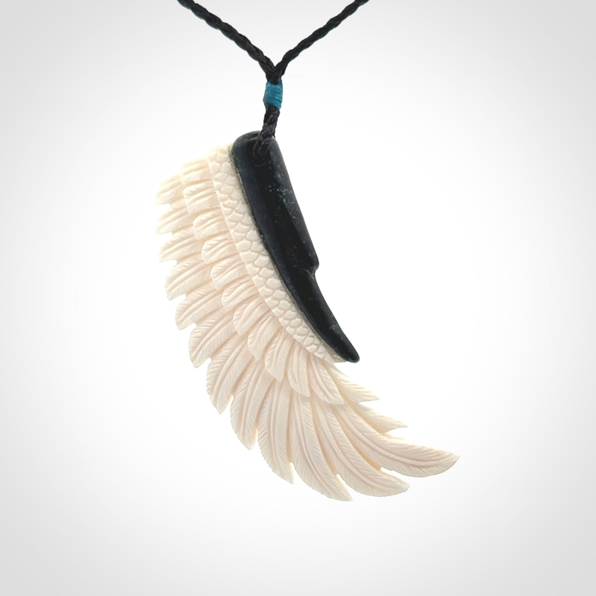 This photo shows a beautiful bone and jade wing pendant.