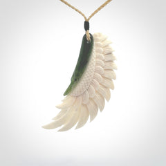 This photo shows a beautiful bone and jade wing pendant.