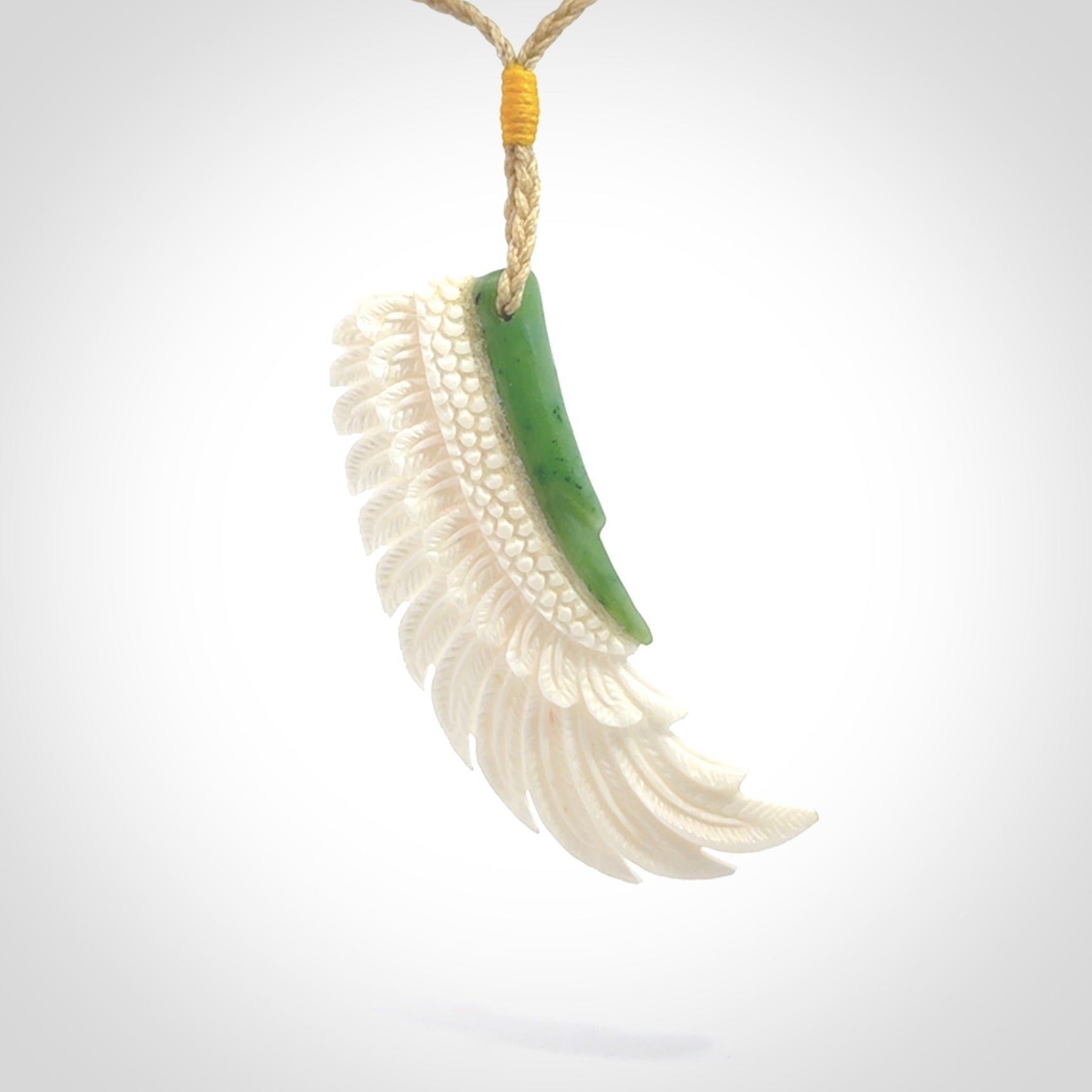 This photo shows a beautiful bone and jade wing pendant.