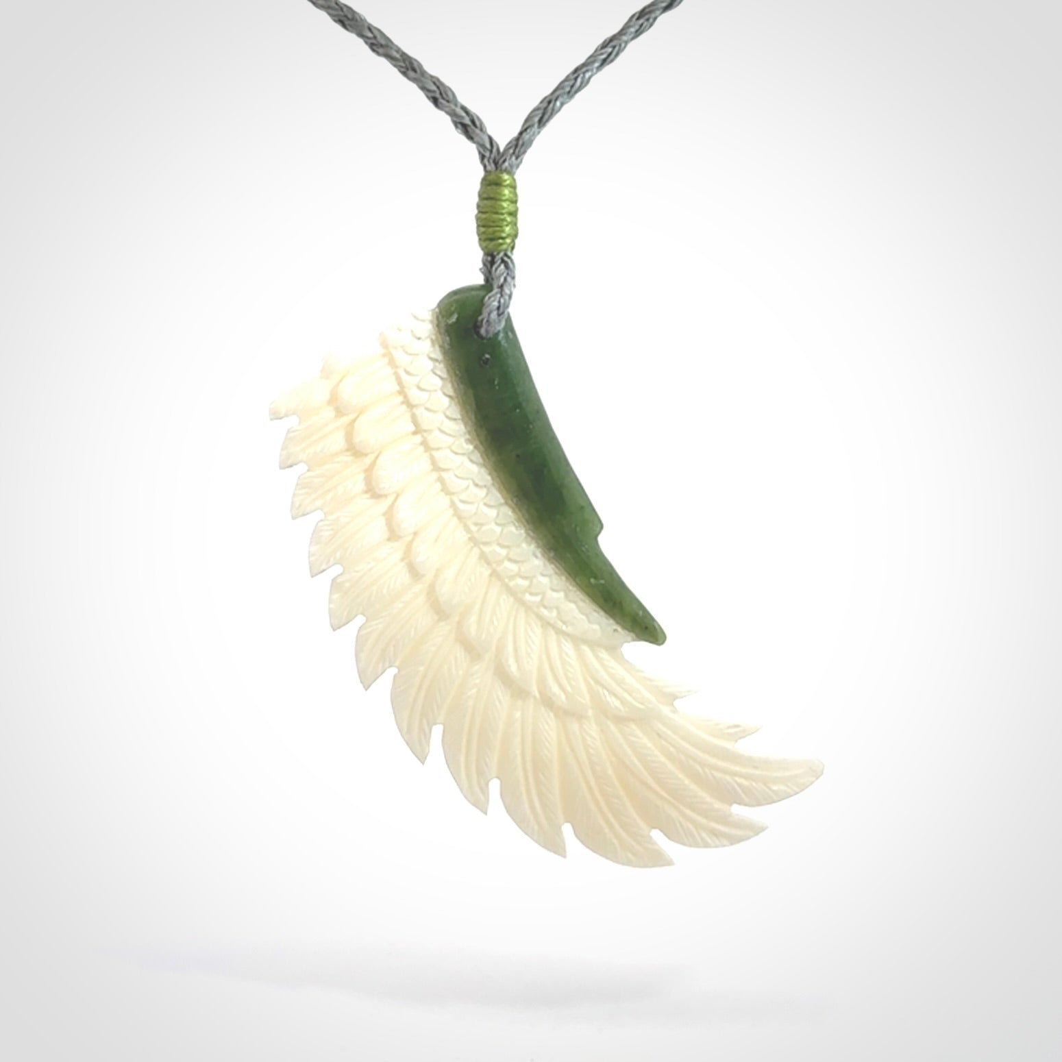 This photo shows a beautiful bone and jade wing pendant.