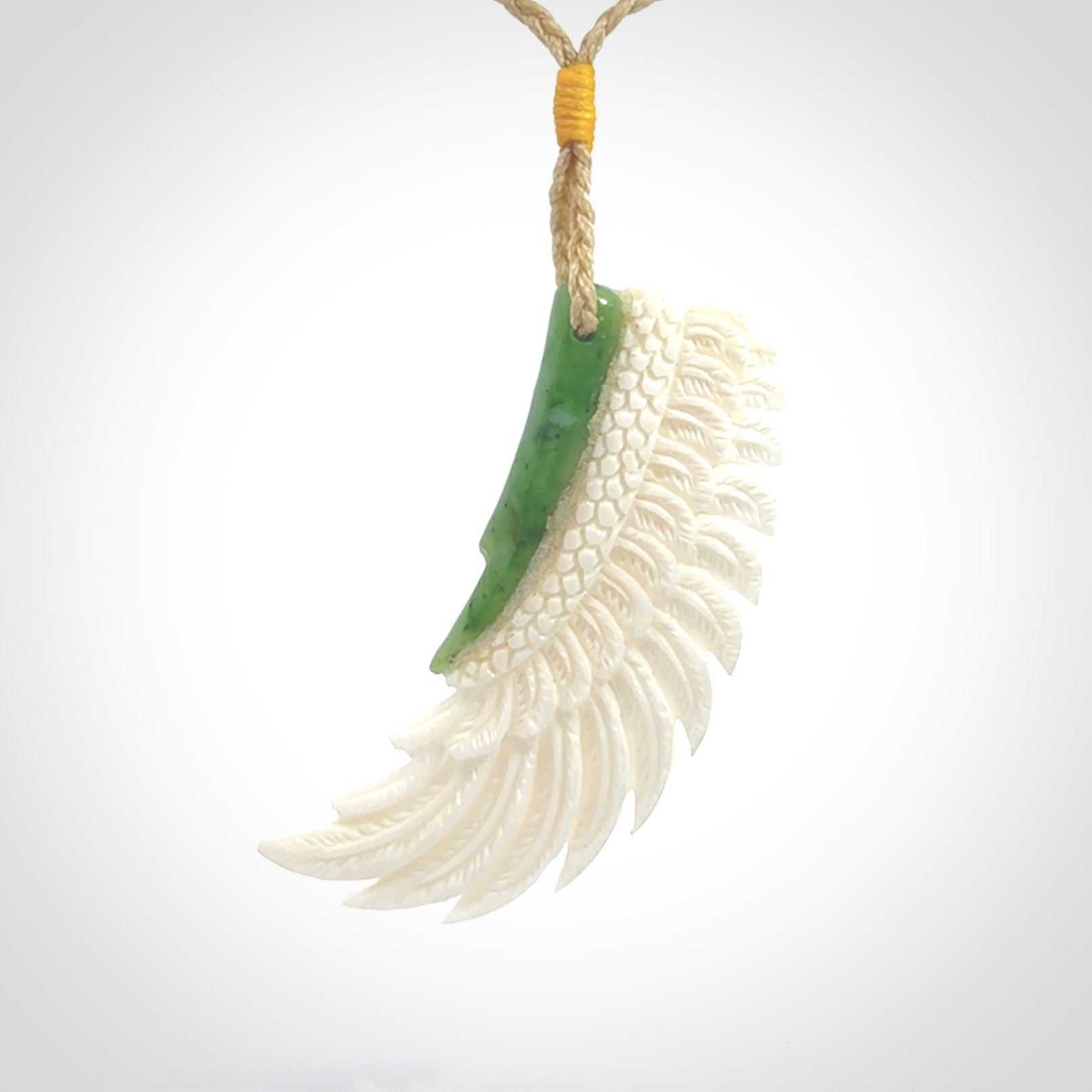 This photo shows a beautiful bone and jade wing pendant.