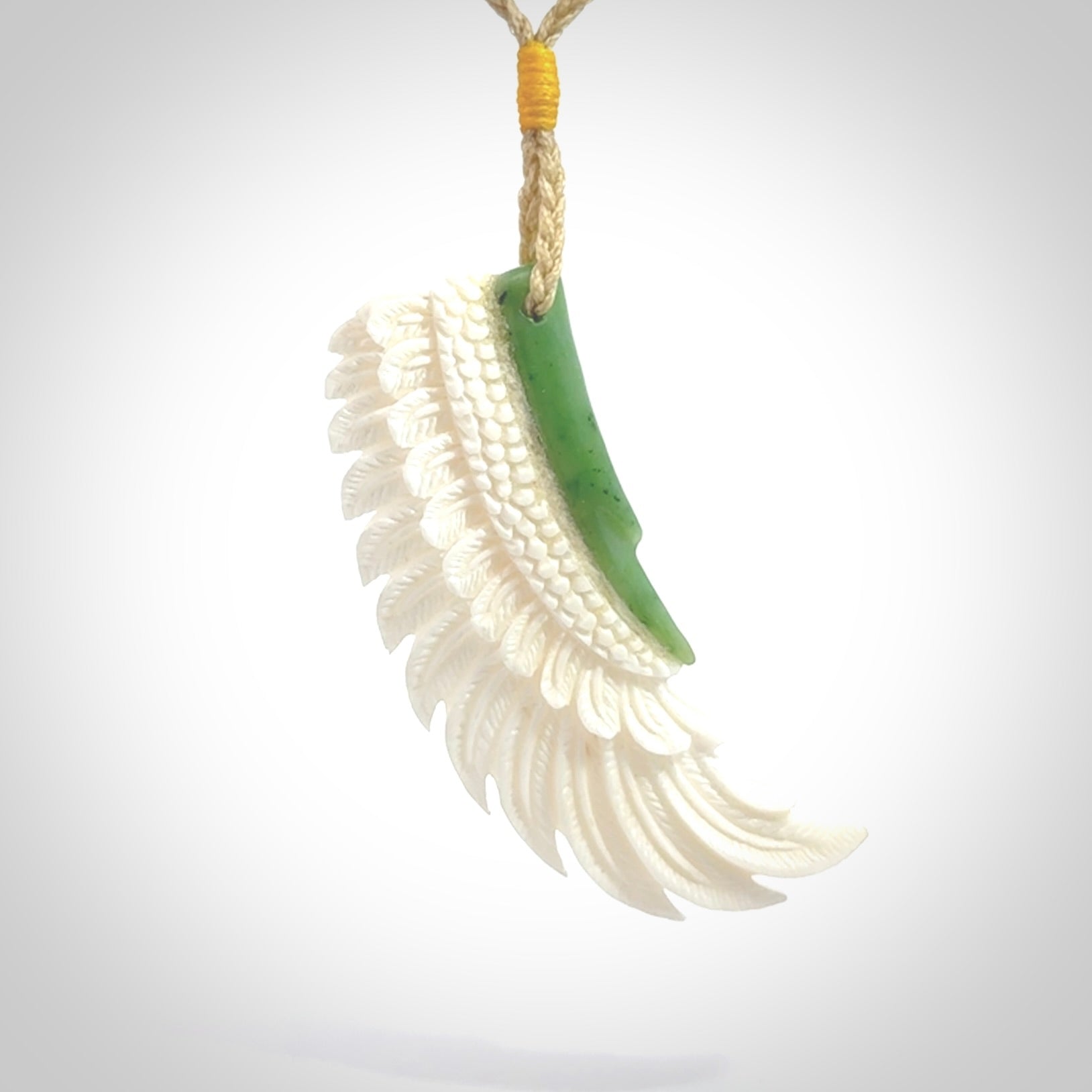 This photo shows a beautiful bone and jade wing pendant.