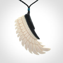 This photo shows a beautiful bone and jade wing pendant.