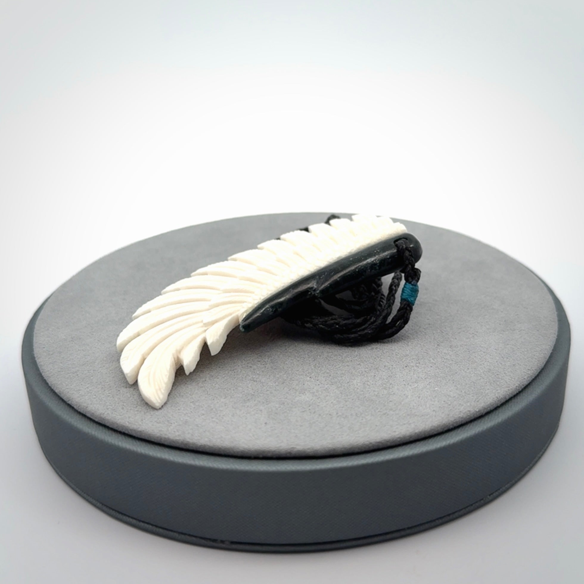 This photo shows a beautiful bone and jade wing pendant.