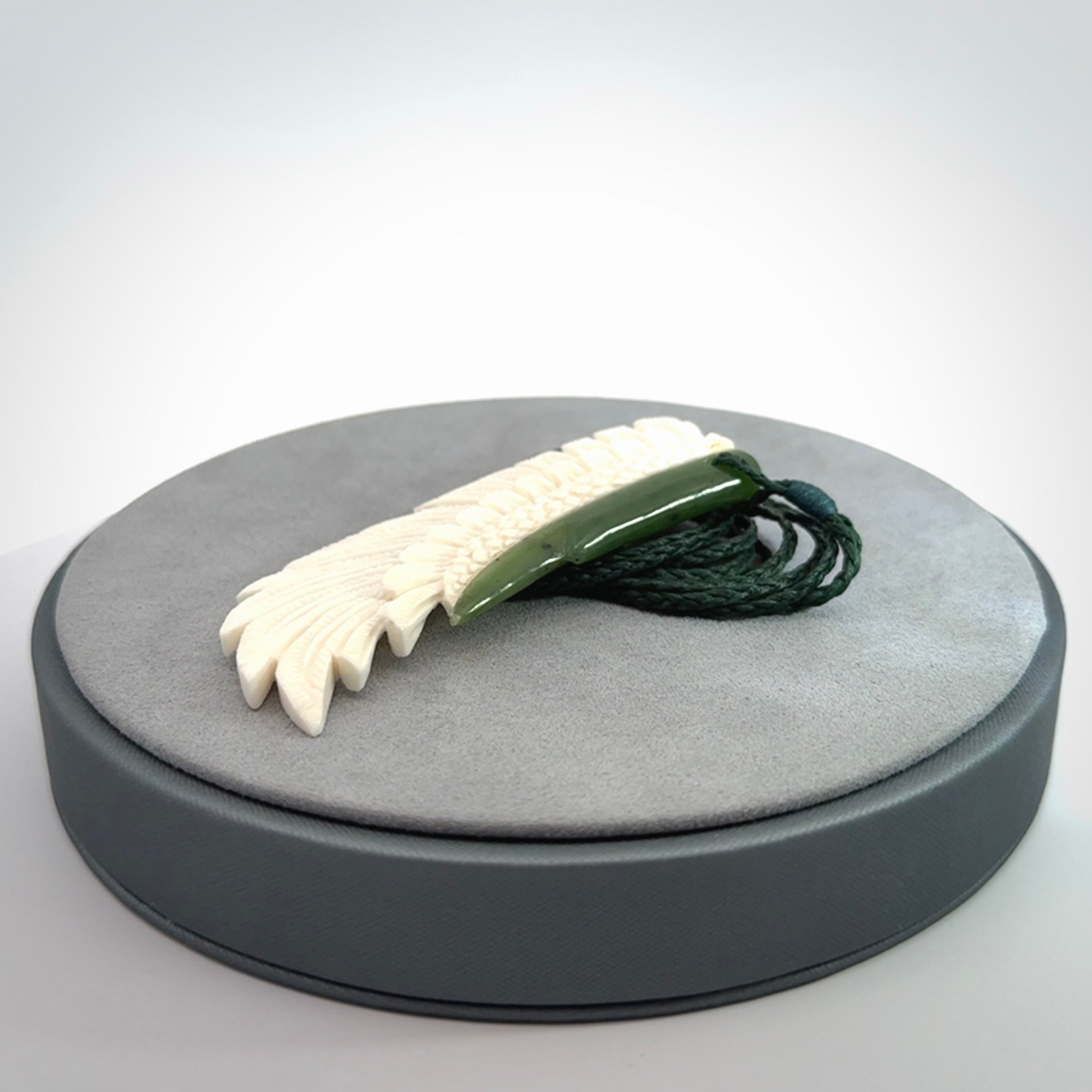 This photo shows a beautiful bone and jade wing pendant.