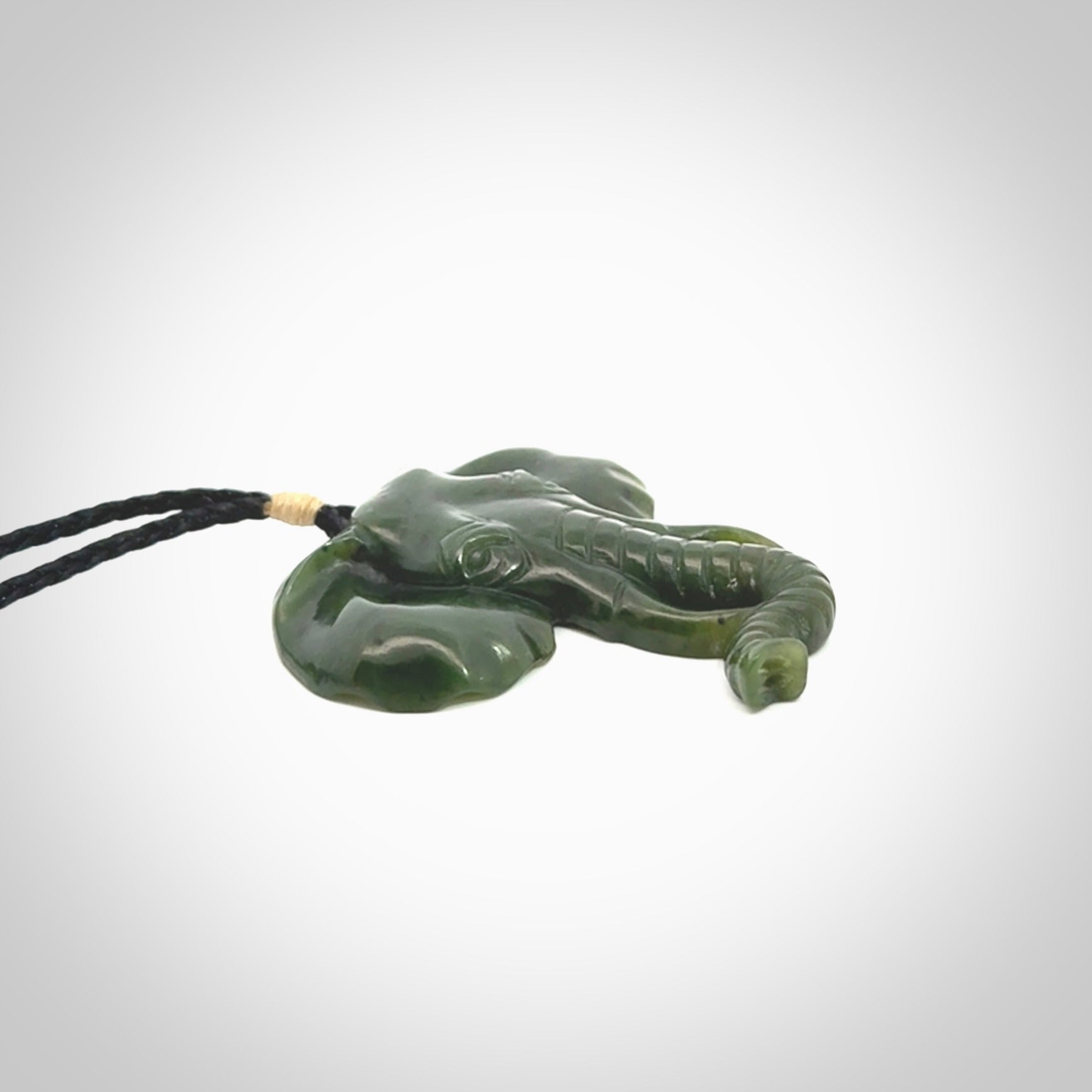 This is a hand made elephant pendant. Carved in a beautiful darker green piece of British Columbian jade. The cord is hand-plaited in a black colour and is length adjustable. Provided in a woven kete pouch and delivered with express courier.