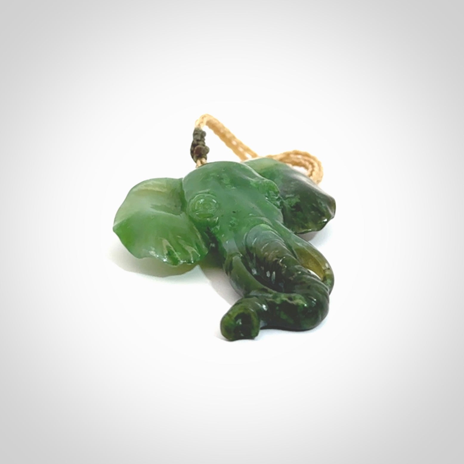 This is a hand made elephant pendant. Carved in a beautiful darker green piece of Aceh jade. The cord is hand-plaited in an Oat colour and is length adjustable. Provided in a woven kete pouch and delivered with express courier.